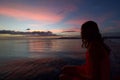 Tropical sunset with scenic colors of the sky and young woman si Royalty Free Stock Photo