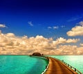 Tropical sunset seascape. overwater bungalow with jetty