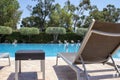 Tropical Swimming Pool. Sunbeds Near Pool Ladder in Swimming Pool with Blue Water Royalty Free Stock Photo