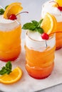 Tropical tiki cocktail with orange juice and rum in a fun tiki glass topped with cold foam Royalty Free Stock Photo