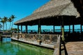 Tropical Tiki Hut restaurant built out over the water with boats small on the horizon