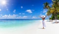 A tropical travel concept banner with copy space showing a woman walking down a paradise beach