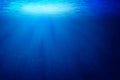 Tropical underwater dark blue deep ocean wide nature background with rays of sunlight. Royalty Free Stock Photo