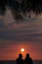 Tropical Vacation Couple on Beach Watching Sunset Royalty Free Stock Photo