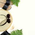 Tropical vacation pattern. Straw beach sunhat, sunglasses, beach slaps, leaf of fern on white background. Top view with copy spac Royalty Free Stock Photo