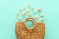 Tropical vacation and summer travel concept with wicker beach bag and seashells over pastel mint blue background. Top view Royalty Free Stock Photo