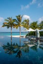 Tropical vertical landscape of swimming pool near ocean at the luxury island resort Royalty Free Stock Photo