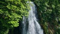 Tropical waterfall cascading down rocky ledges drone shot. Serene lush paradise