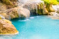 Tropical waterfall with emerald blue lake and rocks in jungle forest Royalty Free Stock Photo