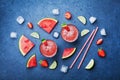 Tropical watermelon smoothie with slices of fruit on blue table top view in flat lay style. Summer detox juice.