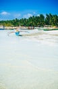 Tropical white sand beach with green palm trees and parked fishing boats in the sand. Exotic island paradise Royalty Free Stock Photo