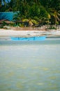 Tropical white sand beach with green palm trees and parked fishing boats in the sand. Exotic island paradise Royalty Free Stock Photo