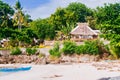 Tropical white sand beach with green palm trees and parked fishing boats in the sand. Exotic island paradise Royalty Free Stock Photo