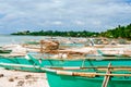 Tropical white sand beach with green palm trees and parked fishing boats in the sand. Exotic island paradise Royalty Free Stock Photo