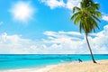 Tropical yellow sand beach landscape, turquoise sea water, blue sky,  bright sun, white clouds, palm tree, boat, summer holidays Royalty Free Stock Photo
