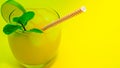 Tropicana cocktail with a straw on a yellow background. Alcoholic drink with mint and orange slice. Natural orange juice Royalty Free Stock Photo