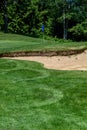 Trouble on the golf course, sand trap protecting a golf green with trees in the background Royalty Free Stock Photo