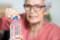 Trouble opening the bottle of drinking water in the elderly age,life problem,senior woman with numbness and weakness of hands and Royalty Free Stock Photo