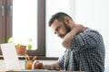 Troubled bearded man massages aching neck. Royalty Free Stock Photo