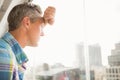 Troubled casual businessman leaning against window