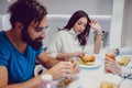 Troubled couple eating dinner with friends