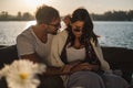 Troubled couple holding hands while sitting by the river Royalty Free Stock Photo