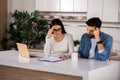 Troubled couple sitting in the kitchen