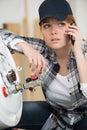 troubled female plumber making telephone call