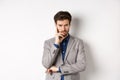 Troubled frowning business man in suit looking at camera pensive, thinking or making decision, standing on white Royalty Free Stock Photo