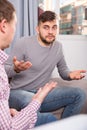 Troubled man talking with friend on sofa Royalty Free Stock Photo