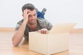 Troubled man open a moving box at home Royalty Free Stock Photo