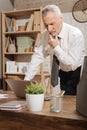 Troubled office worker rubbing his chin