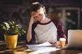 Troubled young female designer reading paper at coffee shop