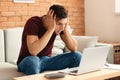 Troubled young man after making mistake while working with laptop at home Royalty Free Stock Photo