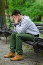 Troubled young man sitting in the park Royalty Free Stock Photo