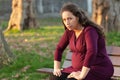 Troubled young pregnant woman on a park bench