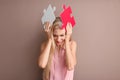 Troubled young woman with pieces of puzzle on color background