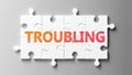 Troubling complex like a puzzle - pictured as word Troubling on a puzzle pieces to show that Troubling can be difficult and needs Royalty Free Stock Photo