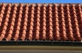 The trough of two roofs bent into a turn with Italian folded tiles and a metal gutter. you can see the ridge of the roof with conc