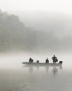 Trout fishermen in a Jon boat on a foggy morning on the White River in Arkansas