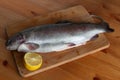 Trout and lemon lying on a chopping board