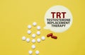 TRT words on sticker with pills man on yellow background