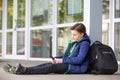 Truancy concept, young boy staying away from the school and playing games on mobile or smartphone, absence from school Royalty Free Stock Photo