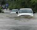 A truck and car attempt to drive on a flooded street in Greenwood, Indiana. This is a photo