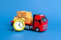 A truck with cargo cardboard boxes and a yellow alarm clock. Express delivery in short time concept. Temporary storage, limited Royalty Free Stock Photo