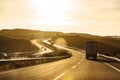 Truck and cars driving on highway at sunset