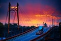 Truck with container rides over the bridge, beautiful sunset, freight cars in industrial seaport, the road goes up