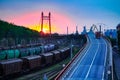 Truck with container rides on the road, railroad transportation, freight cars in industrial seaport at sunset Royalty Free Stock Photo