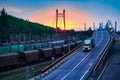 Truck with container rides on the road, railroad transportation, freight cars in industrial seaport at sunset Royalty Free Stock Photo