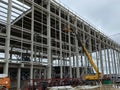 Truck crane with spread out legs and an extended boom is at construction site